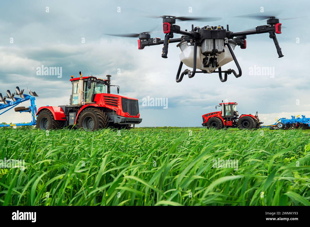 Tecnologie moderne in agricoltura. Un drone industriale vola su un campo verde. i trattori coltivano il terreno nelle aree rurali. Il concetto di tecnologia Foto Stock