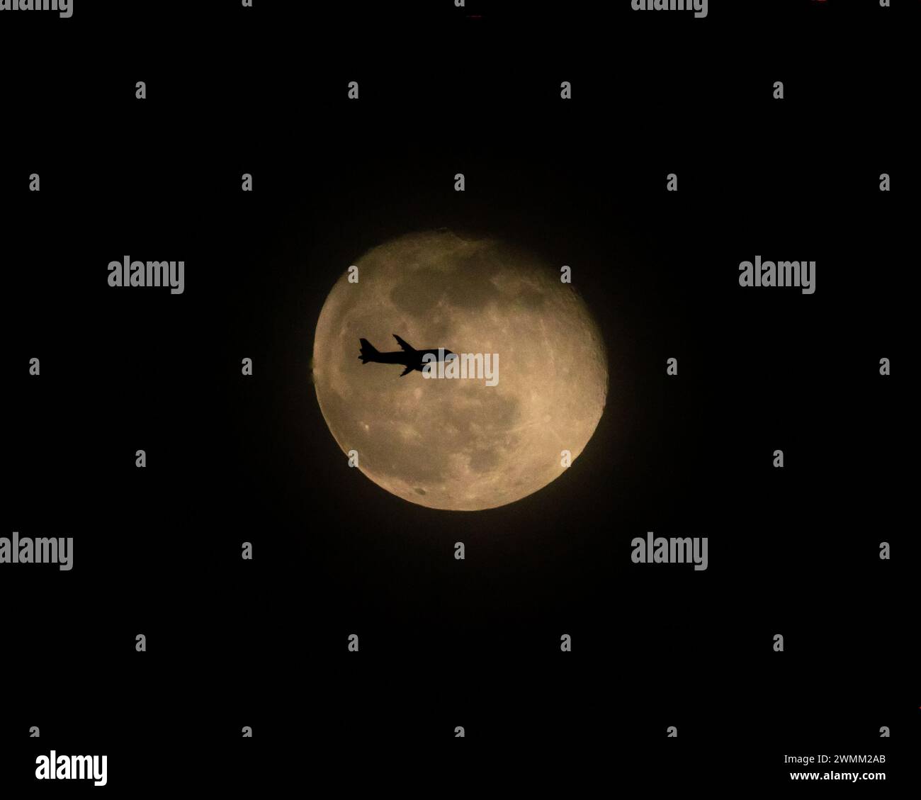Volo commerciale di linea di fronte alla Luna piena di notte (1 di 3) Foto Stock