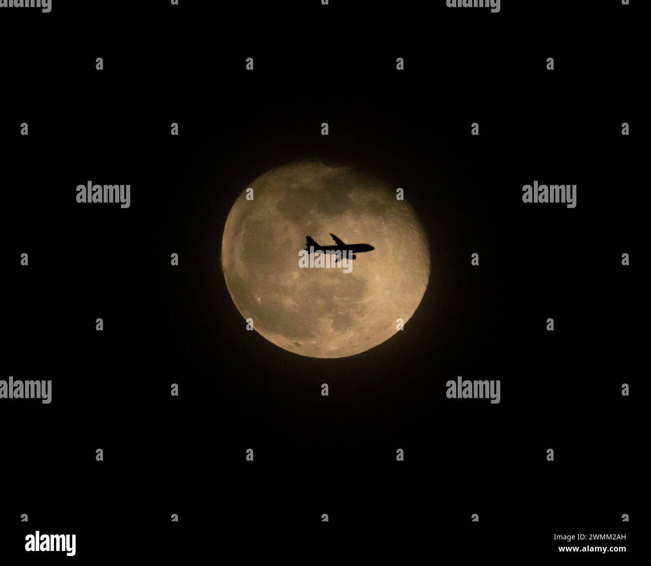 Volo di linea commerciale di notte davanti alla Luna piena (2 di 3) Foto Stock