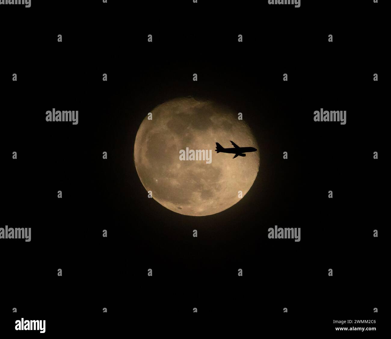 Volo commerciale di linea di fronte alla Luna piena di notte (3 di 3) Foto Stock