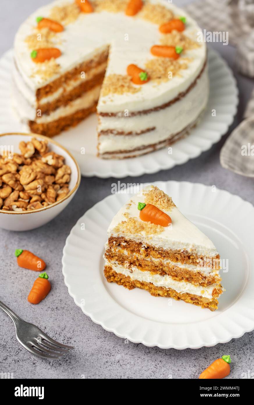 Torta di carote fatta in casa con noci, ghiacciata con formaggio spalmabile. Dolce dolce. Piatto con deliziosa torta di carote Foto Stock