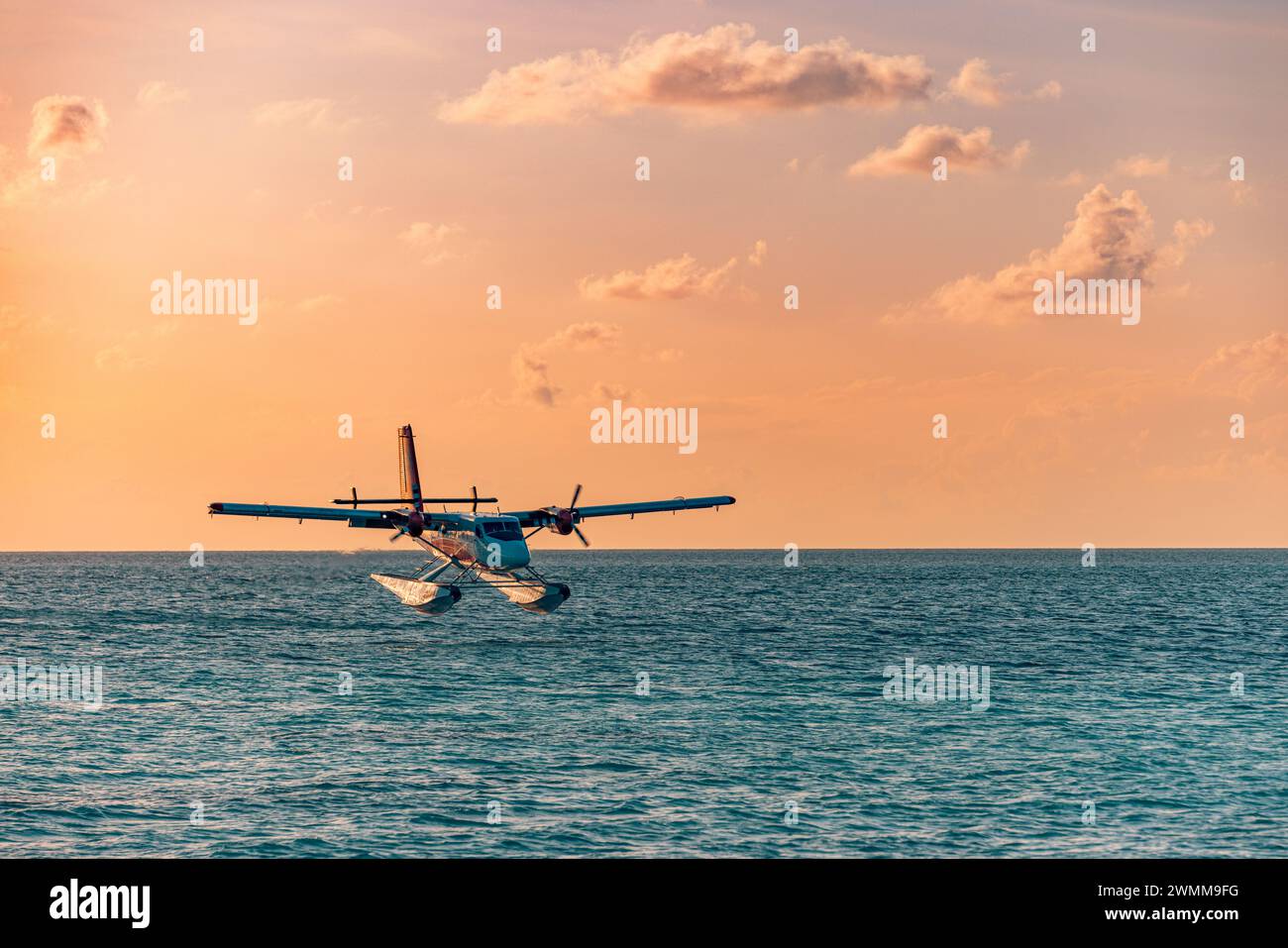 Esotico idrovolante sull'atterraggio sul mare delle Maldive. Atterraggio in idrovolante sul mare al tramonto. Vacanze o vacanze alle Maldive. Trasporto aereo Foto Stock