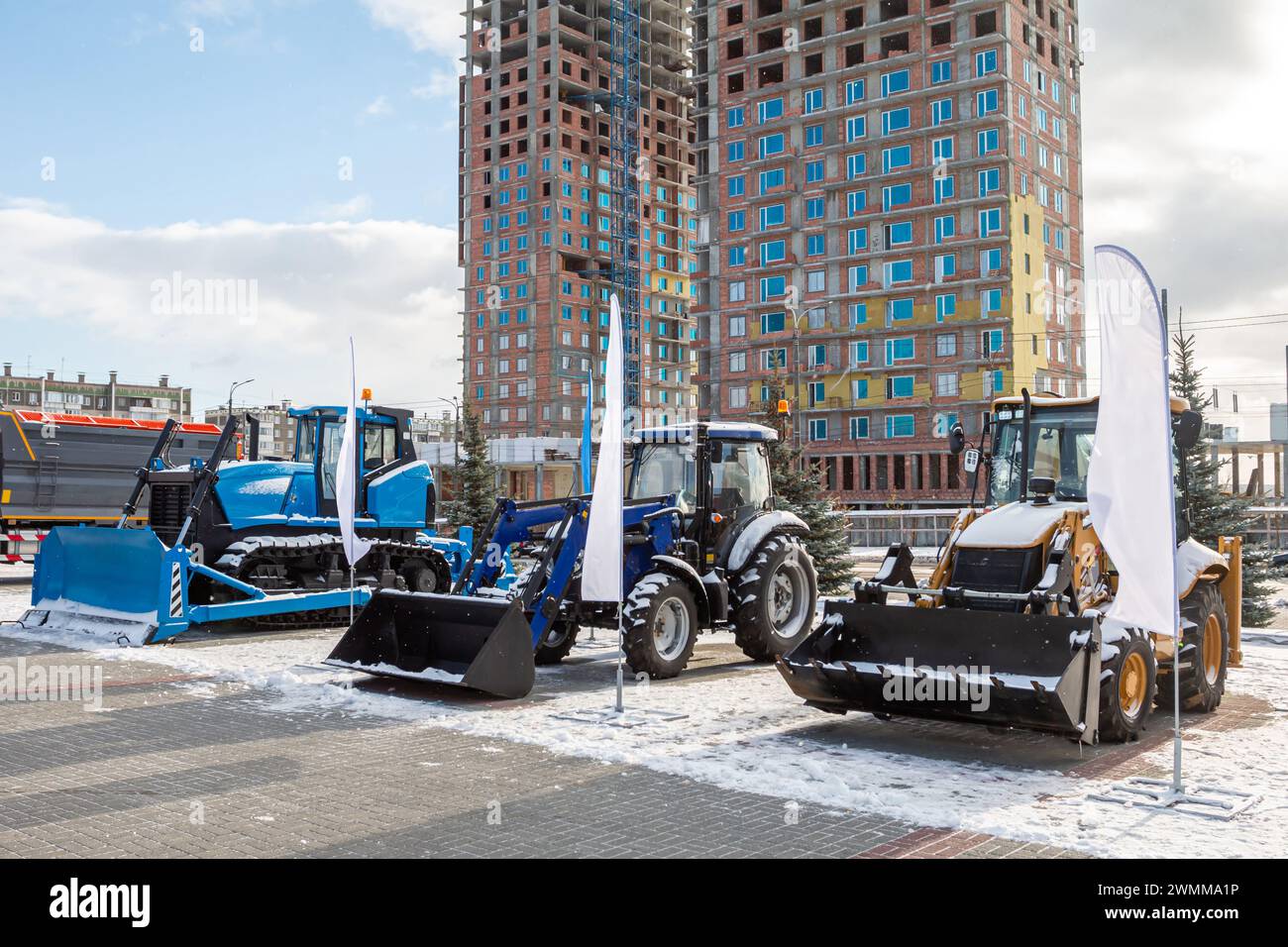 Trattori a due ruote con versoio e bulldozer in occasione di una fiera industriale invernale Foto Stock