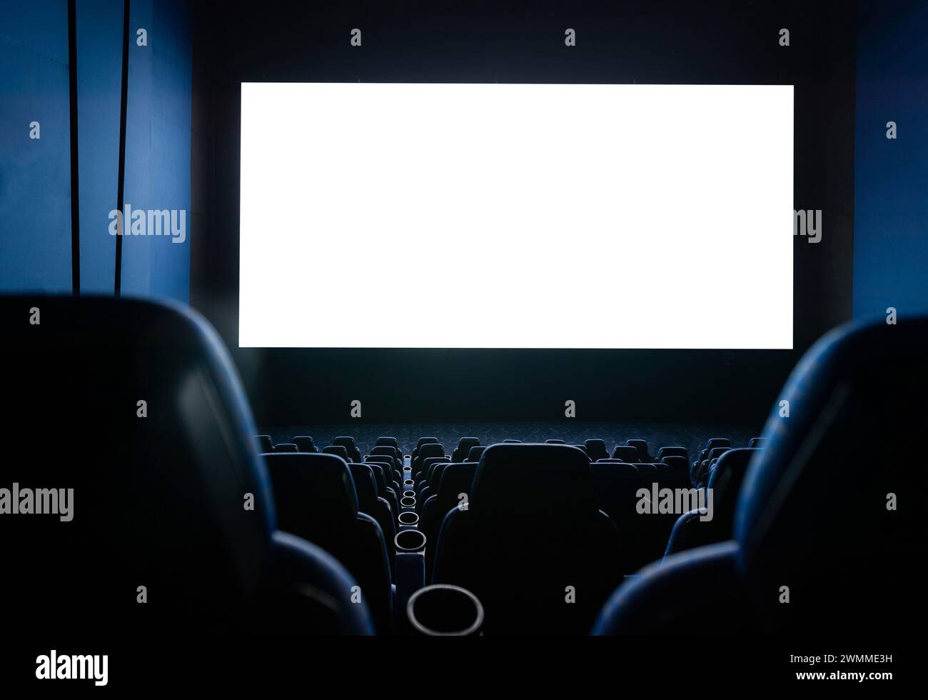 Interni scuri del cinema con schermo e sedie Foto Stock