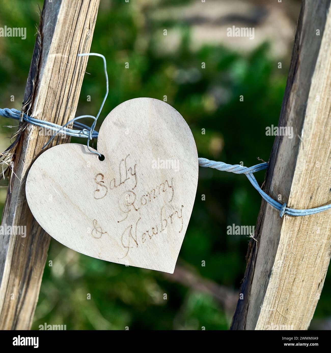 Cuore d'amore in legno attaccato alla recinzione Foto Stock