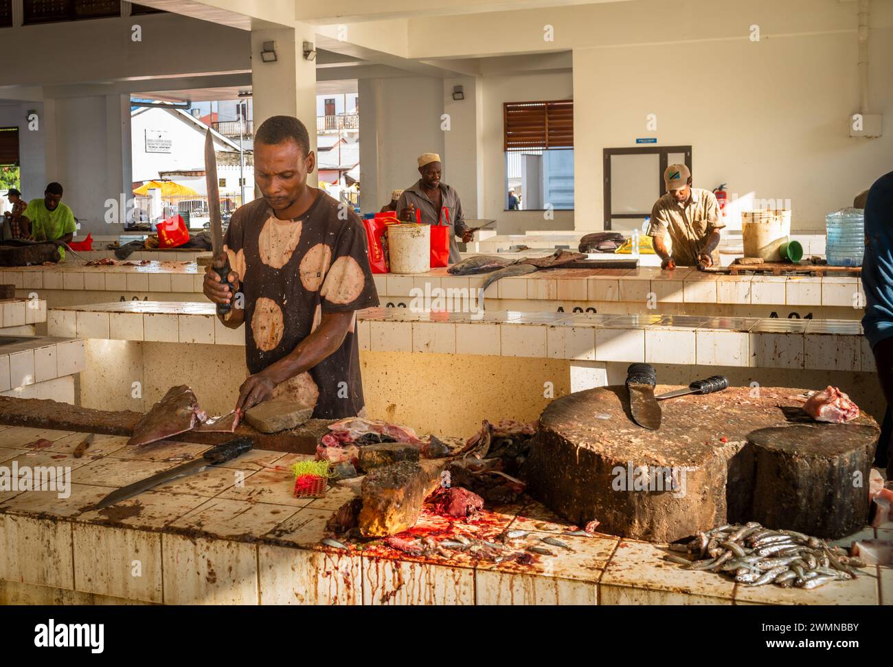 I commercianti lavorano alle loro bancarelle nel Darajani Market, o al mercato del pesce, a Stone Town, Zanzibar, Tanzania. Foto Stock
