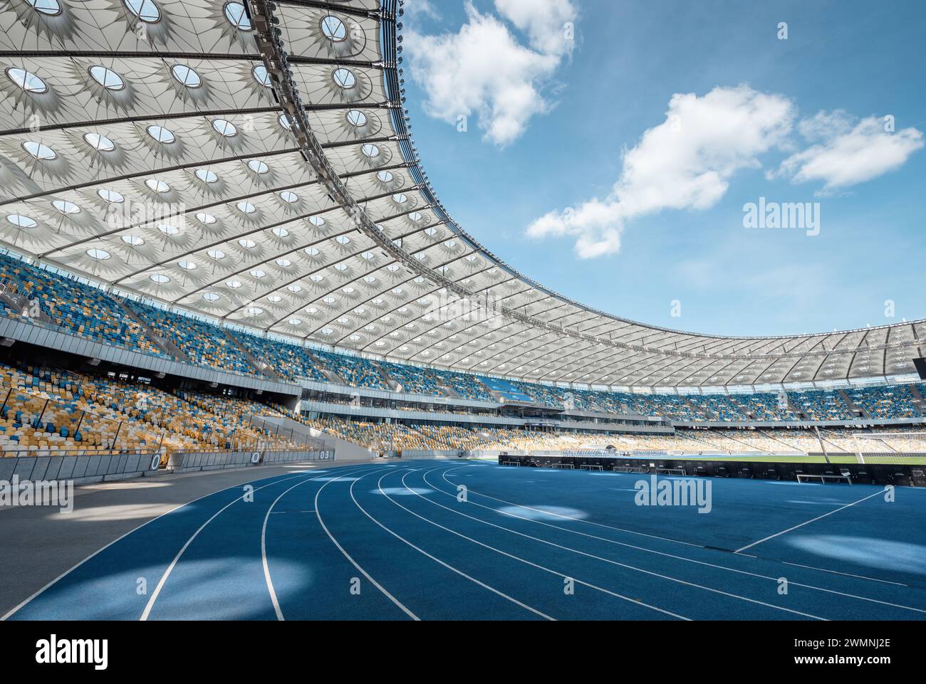 Stadio NSC Olimpico di Kiev ( НСК Олімпійський ). Piste da corsa blu curvate in uno stadio vuoto. Foto Stock