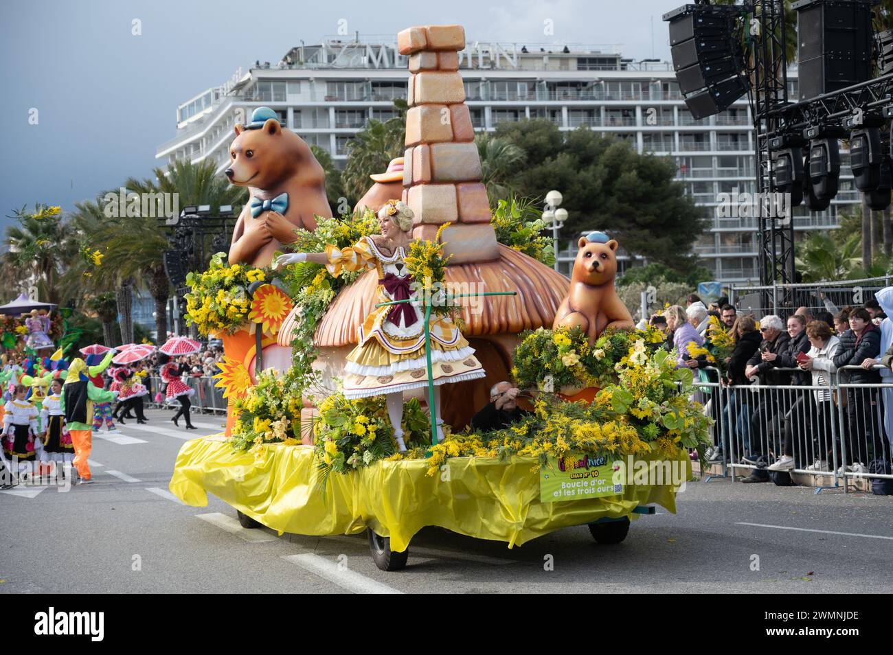 Le donne sui carri allegorici del Carnevale lanciano fiori alla folla nella battaglia dei fiori del carnevale di Nizza - 24 febbraio 2024 Foto Stock