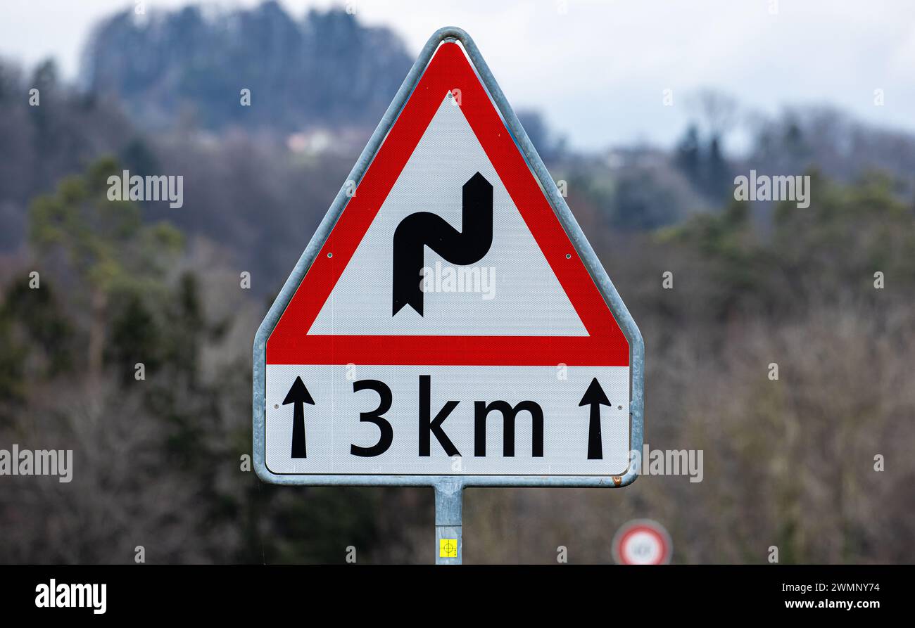 Ein Schild warnt, vor einer Doppelkurve nach rechts beginnend auf eine Streckenlänge von 3 km. (Freienstein-Teufen, Schweiz, 06.03.2023) Foto Stock