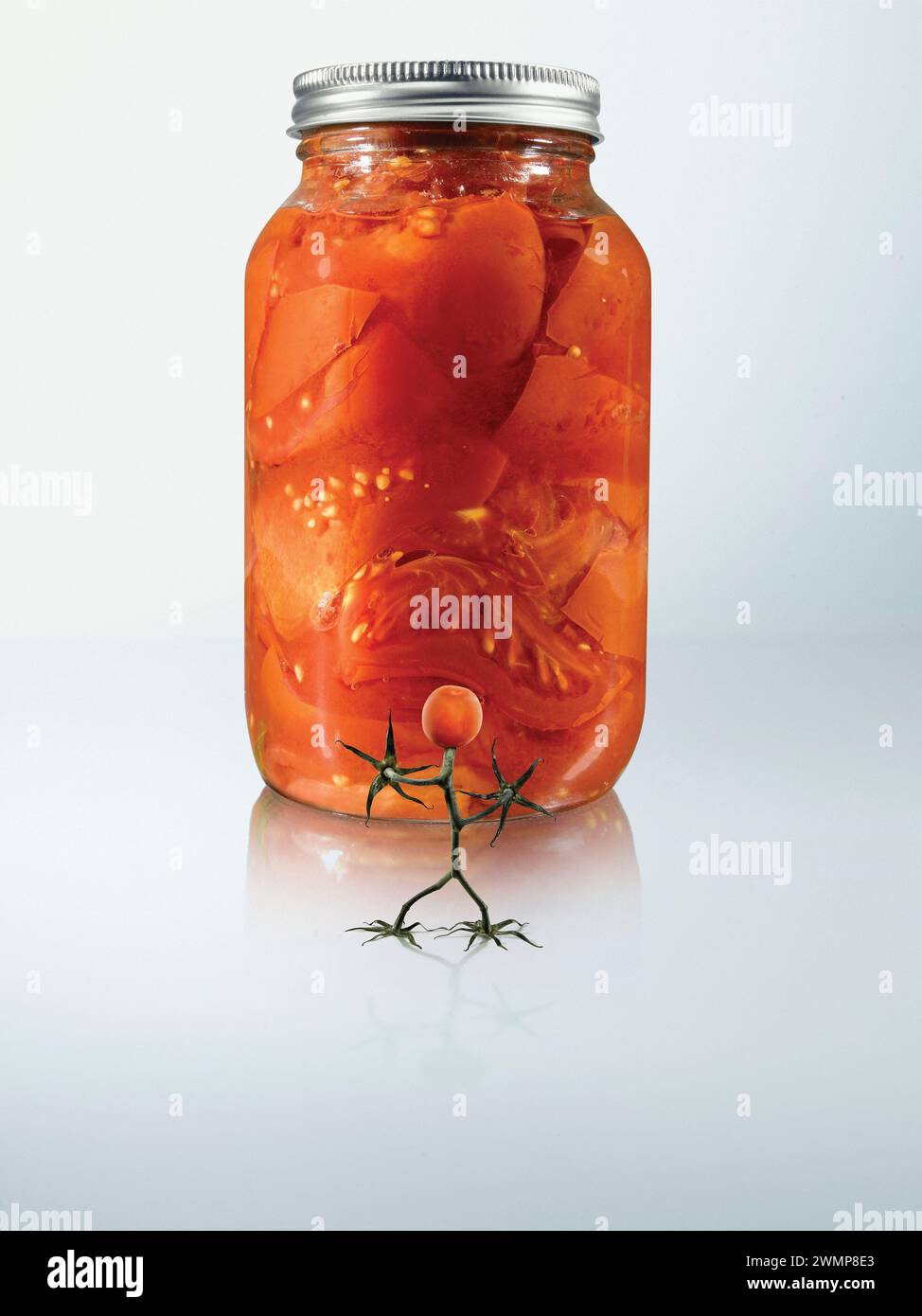 Pomodoro ciliegino simile a un essere umano in piedi davanti a un vasetto di conserve di pomodoro su sfondo bianco; Studio Shot Foto Stock