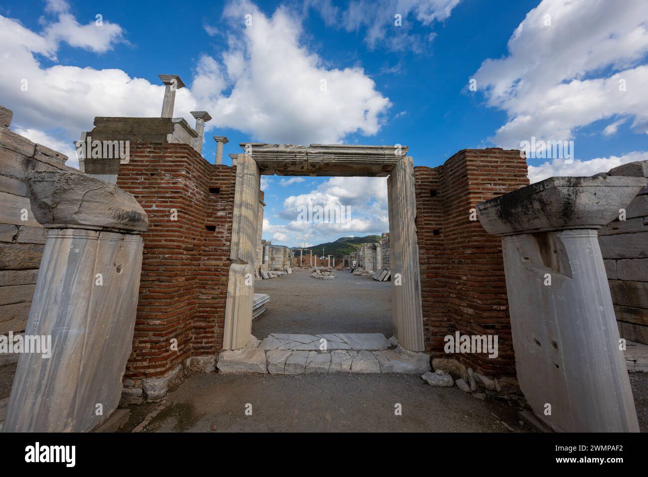 Le colonne e la porta contro un cielo blu con soffici nuvole a Efeso, Turchia Foto Stock