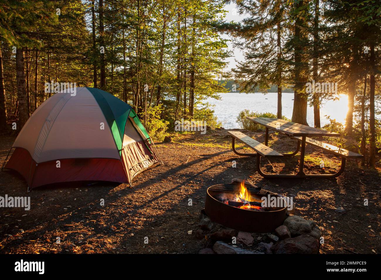 Campeggio sul lago nel Minnesota settentrionale con fuoco al tramonto Foto Stock