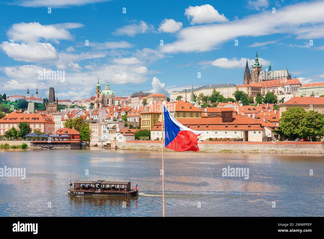 Vista del bellissimo centro storico di Praga, il quartiere vecchio di Mala strana con la chiesa di San Nicola, il castello di Praga, il fiume Moldava e la bandiera nazionale ceca Foto Stock