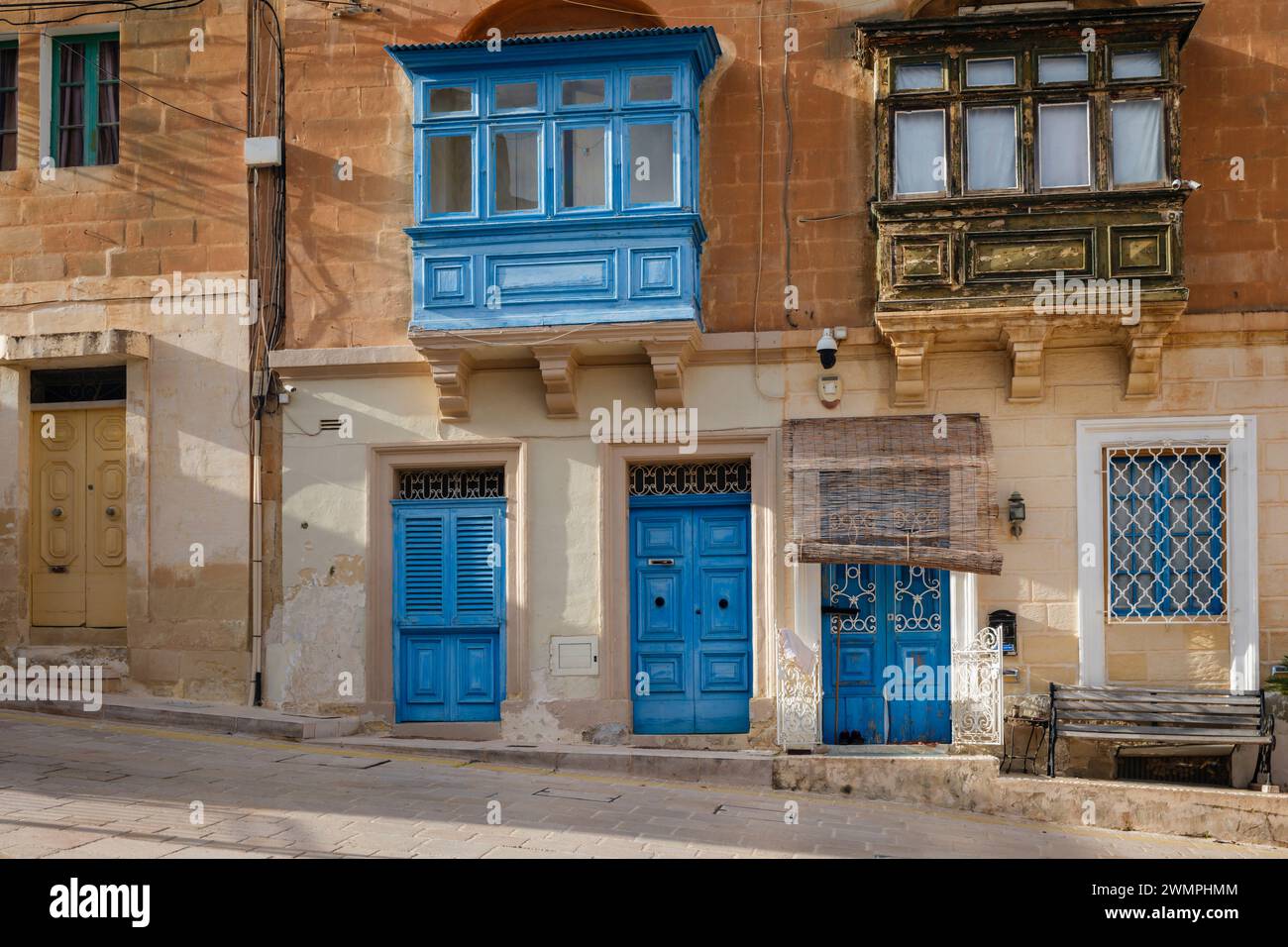 Porte blu e balcone su una casa in stile tradizionale a Kalkara, la Valletta, Malta Foto Stock