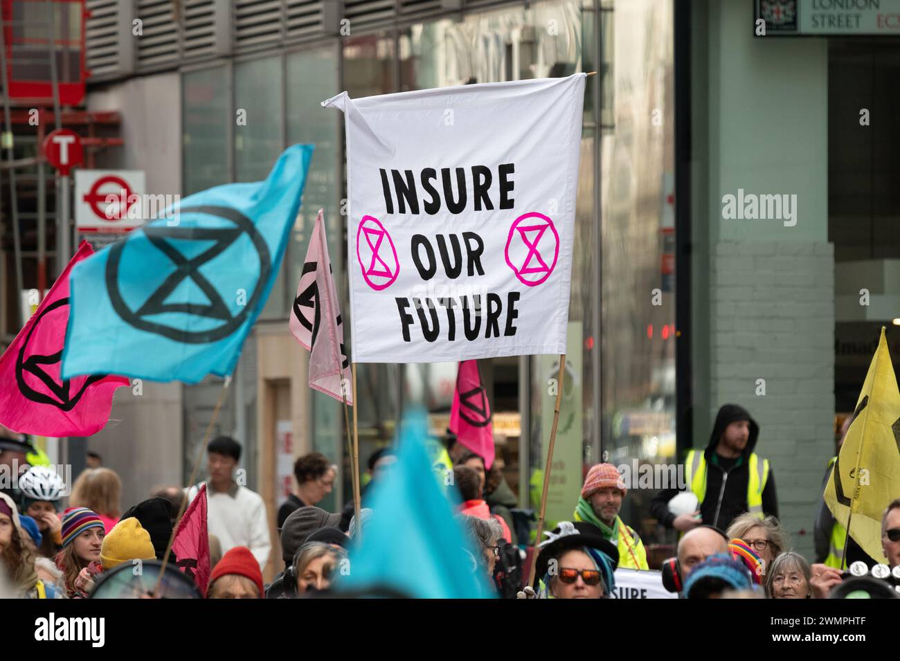 Londra, Regno Unito. 27 febbraio 2024. Gli attivisti per il clima della Extinction Rebellion (XR) marciano intorno al distretto finanziario della City of London visitando compagnie assicurative e invitando l'industria a smettere di assicurare nuovi progetti di combustibili fossili. L'azione faceva parte di una settimana globale di eventi "assicurati il nostro futuro”, sperando di spingere l'industria a fare di più per combattere l'emergenza climatica. Crediti: Ron Fassbender/Alamy Live News Foto Stock