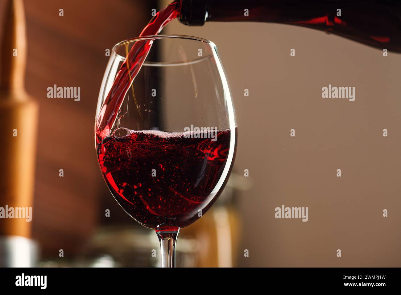 Vino rosso che viene versato in un bicchiere Foto Stock