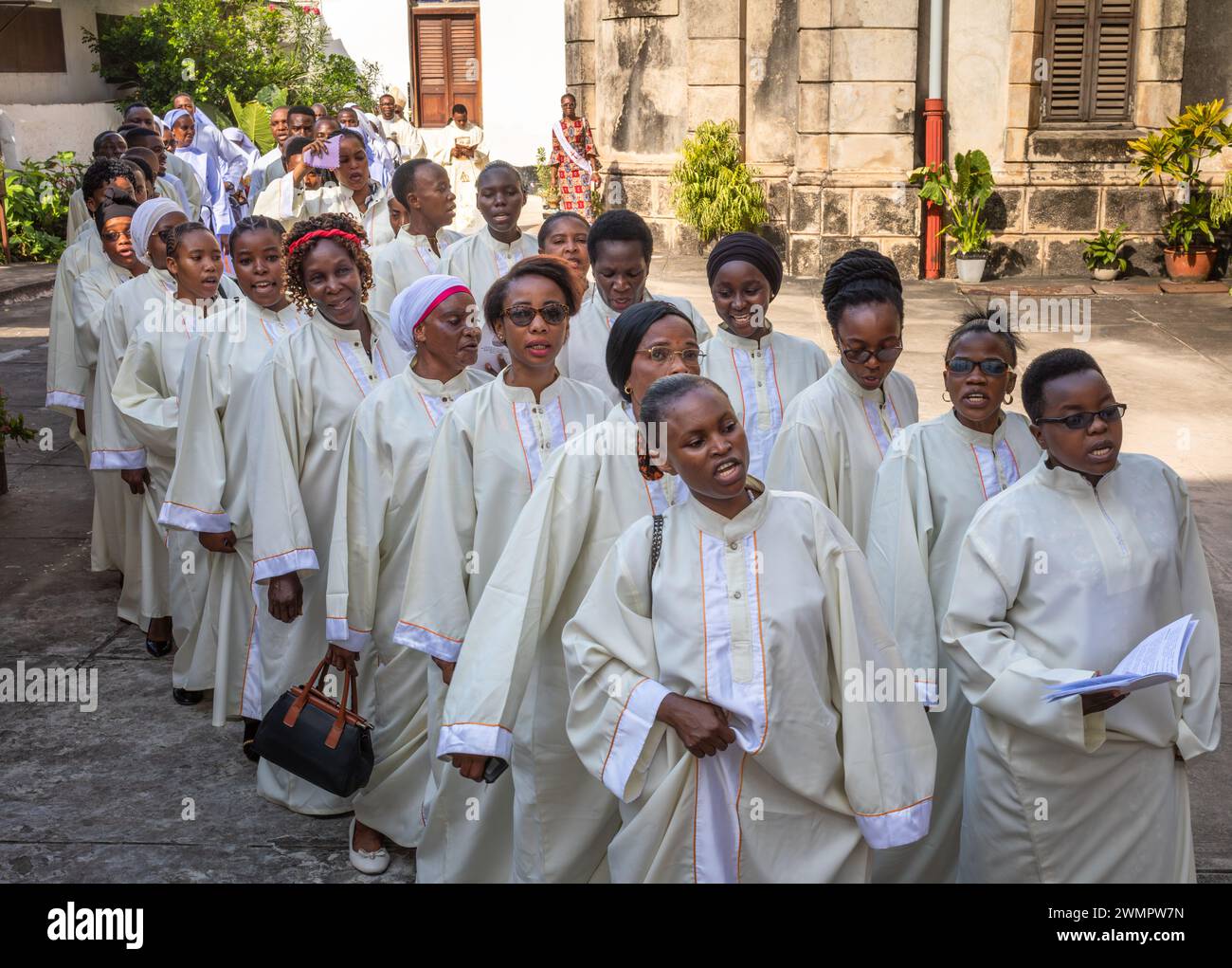 Vestito di bianco, il coro canta mentre entra nella Cattedrale di San Giuseppe per la messa domenicale cattolica a Stone Town, Zanzibar, Tanzania. Foto Stock