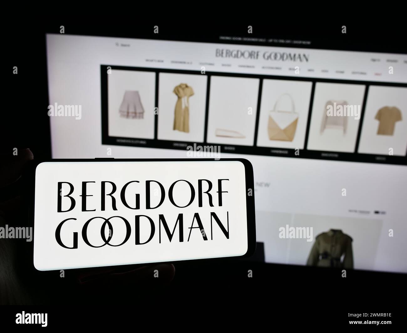 Persona che detiene lo smartphone con il logo della società statunitense di grandi magazzini di lusso Bergdorf Goodman Inc. Davanti al sito Web. Mettere a fuoco il display del telefono. Foto Stock