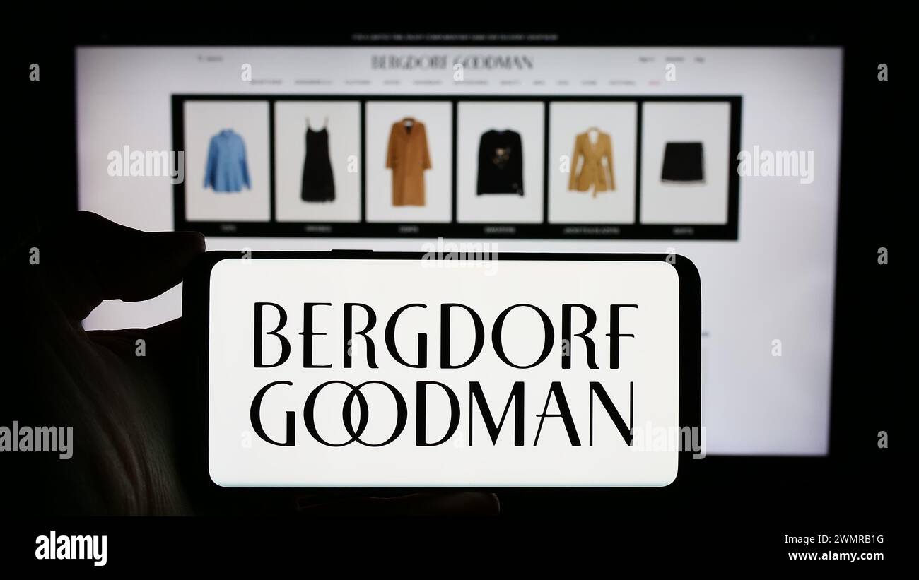 Persona che possiede un telefono cellulare con il logo della società di grandi magazzini di lusso degli Stati Uniti Bergdorf Goodman Inc. Davanti alla pagina Web. Mettere a fuoco il display del telefono. Foto Stock