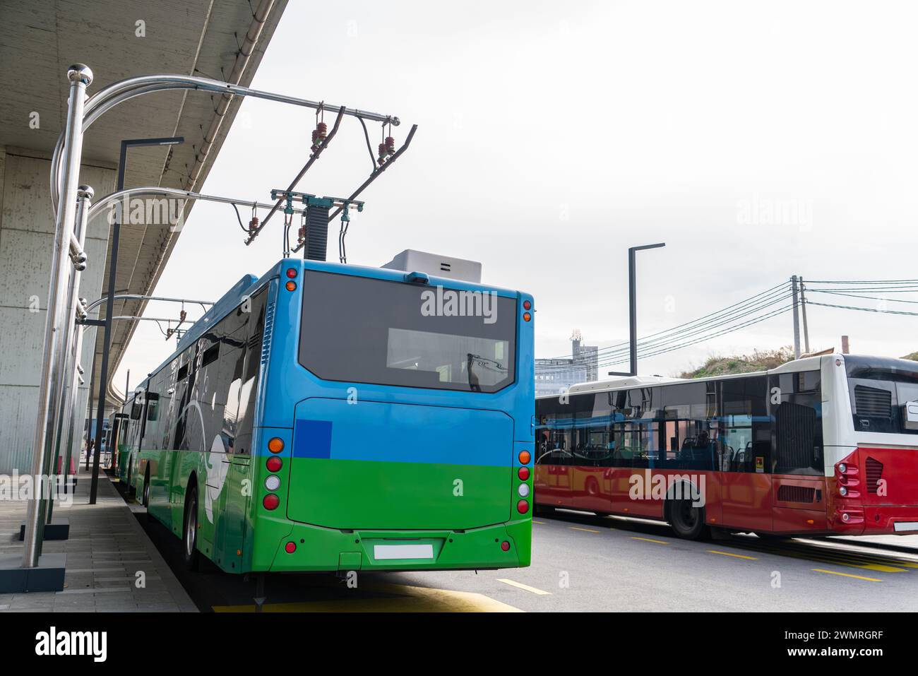 Il bus elettrico a una fermata viene caricato dal pantografo. Mobilità pulita. Foto Stock