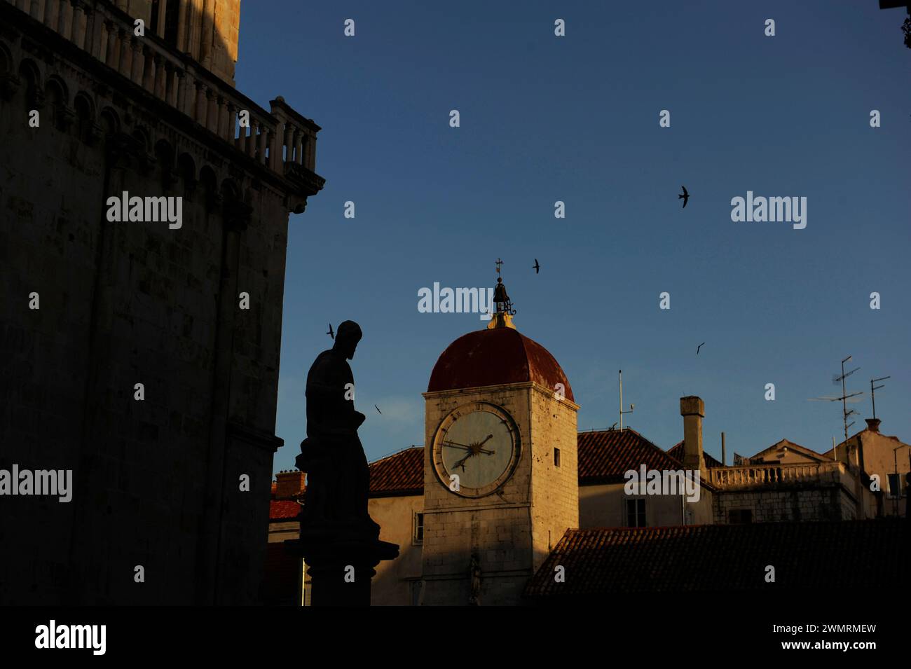 Torre dell'orologio chiesa di San Sebastiano Ivana Piazza Pavla II Trogir in Dalmazia Adriatico, sagoma della statua degli uccelli del cielo blu della Croazia Foto Stock