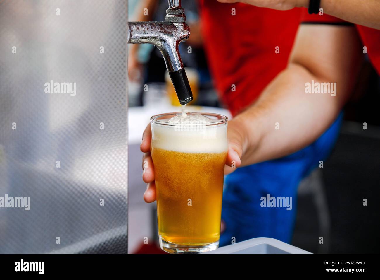 Mano di un barista che serve una birra alla spina con schiuma Foto Stock