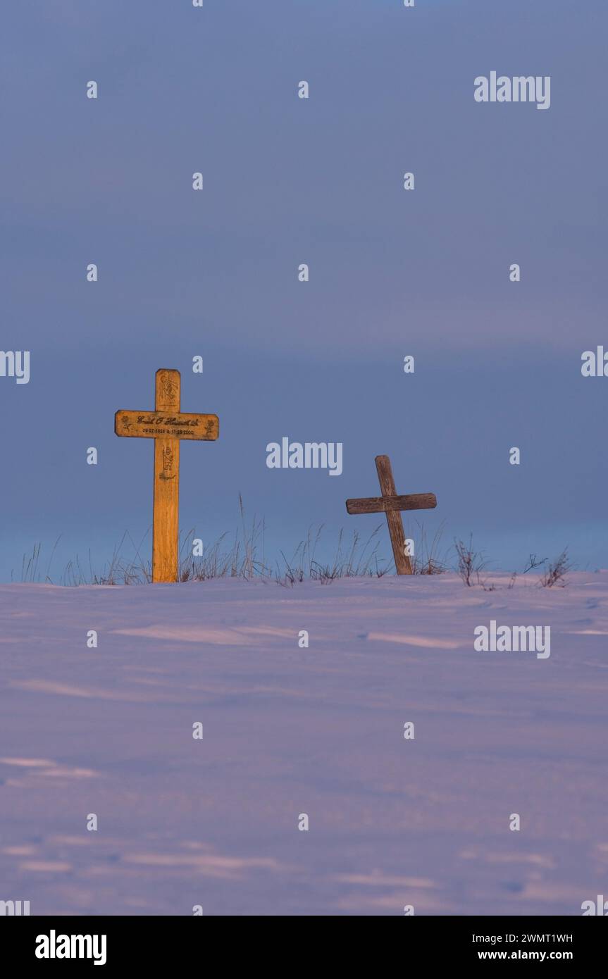 Lapidi su un cimitero collinare appena fuori dal cuore del villaggio Inupiaq di Kotzebue al tramonto nell'Artico nord-occidentale dell'Alaska Foto Stock