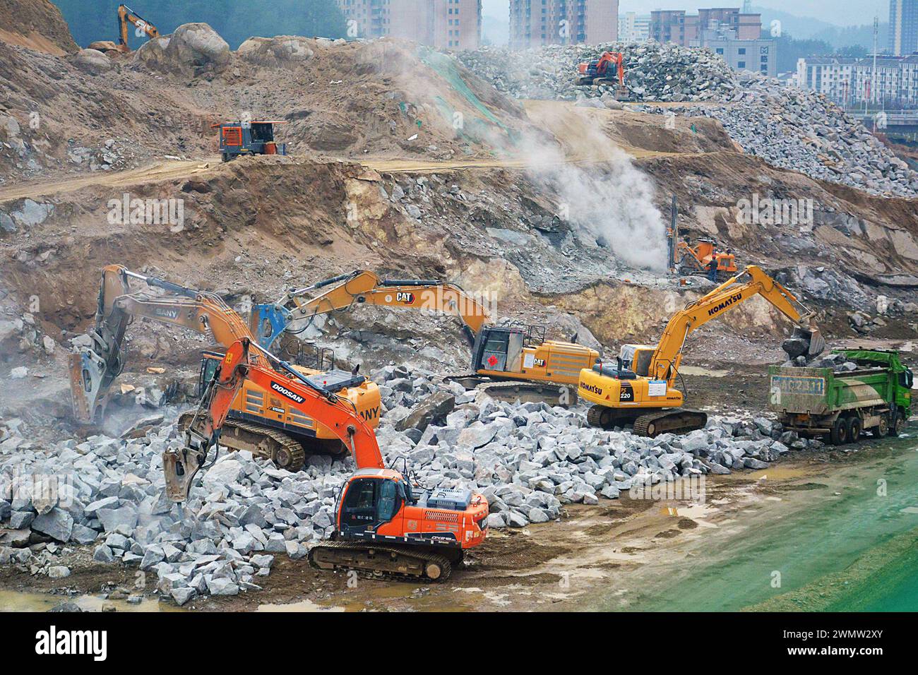 ANQING, CINA - 28 FEBBRAIO 2024 - i lavoratori guidano macchine per costruire infrastrutture di trasporto nella contea di Yuexi, città di Anqing, provincia di Anhui, Cina, Foto Stock