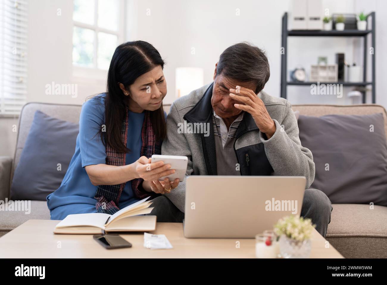 Grave stress asiatico anziani coppia preoccupata per la fattura discutere non pagato debito bancario pagamento carta preoccupazione per problema di denaro Foto Stock