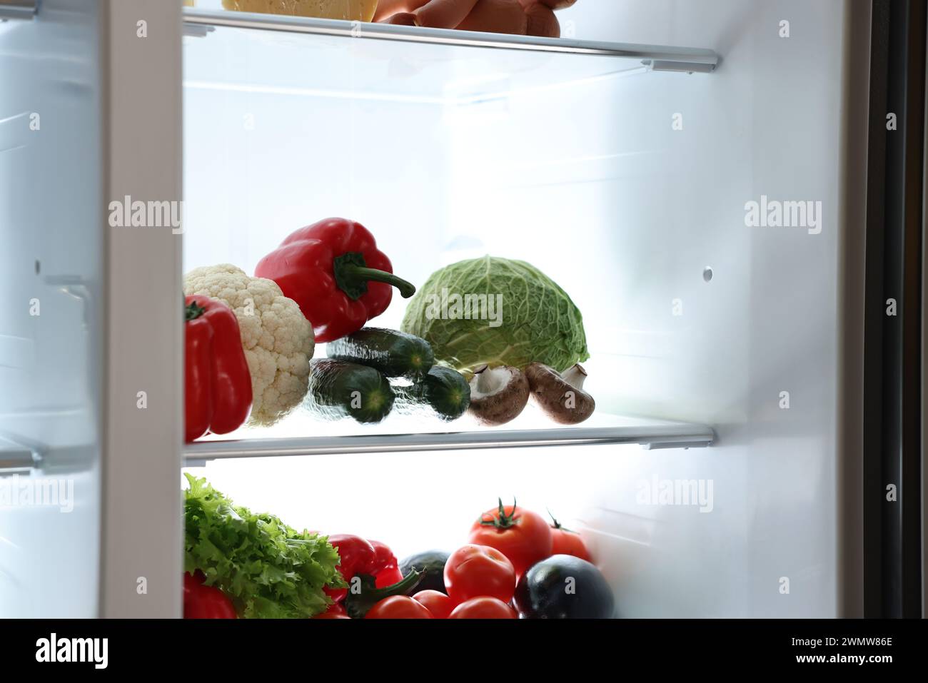 Frigorifero aperto con diversi prodotti al coperto Foto Stock