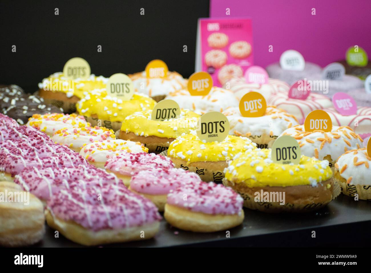 Ciambelle assortite con etichette in esposizione Foto Stock