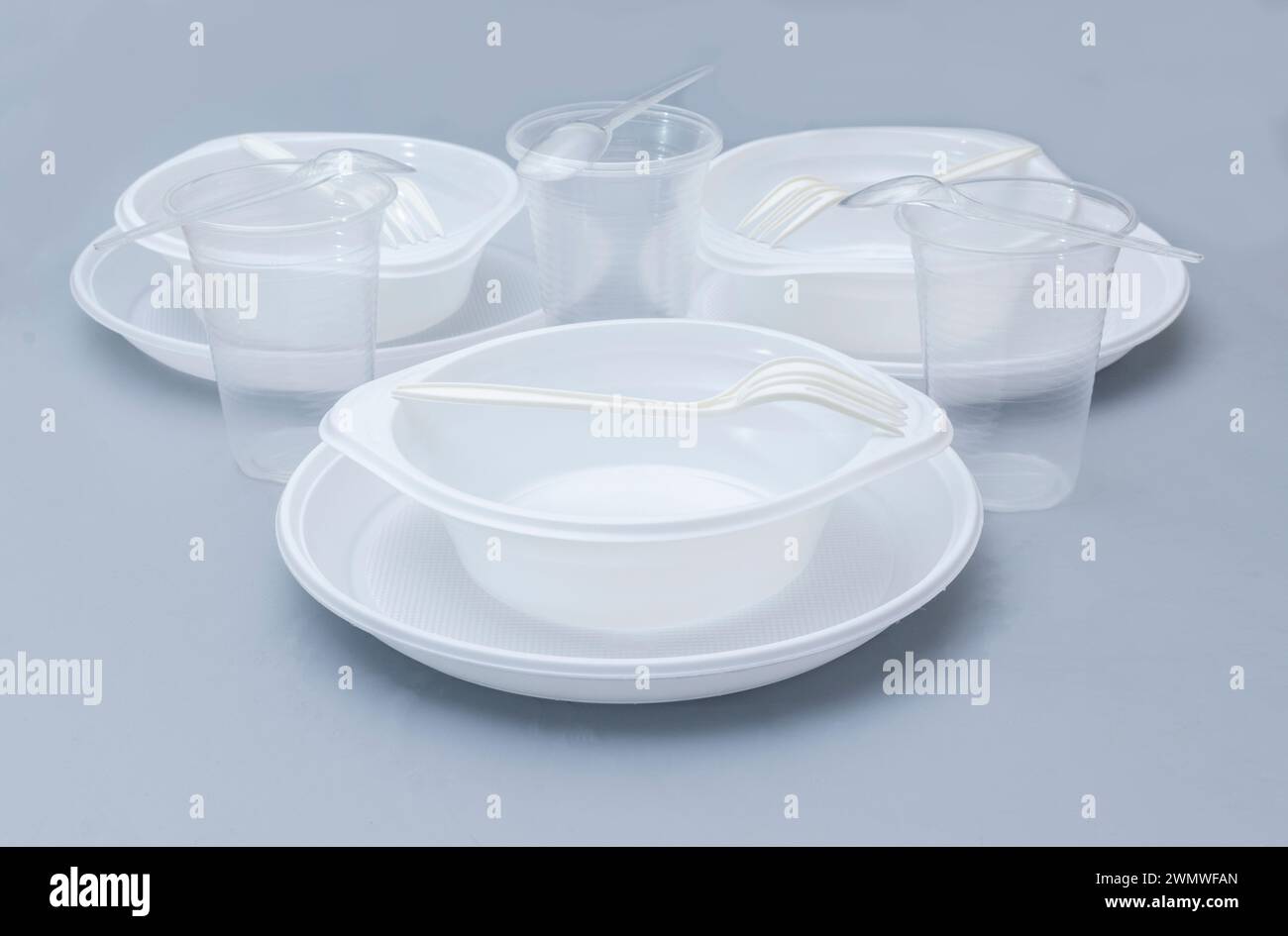 Varie stoviglie monouso in plastica bianca su sfondo blu. Foto Stock