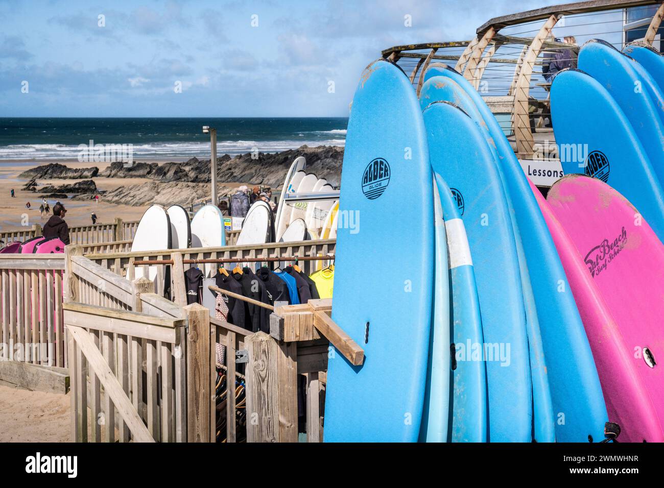 Tavole da surf colorate impilate e disponibili per il noleggio presso il negozio di surf a Fistral Beach a Newquay in Cornovaglia in Inghilterra nel Regno Unito. Foto Stock