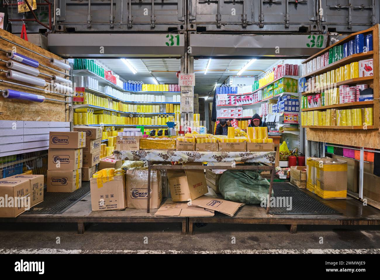 Vista di un negozio, negozio che vende molti tipi di nastro, compreso il nastro trasparente per la spedizione. Al mercato locale Barakholka di container ad Almaty, Kaz Foto Stock