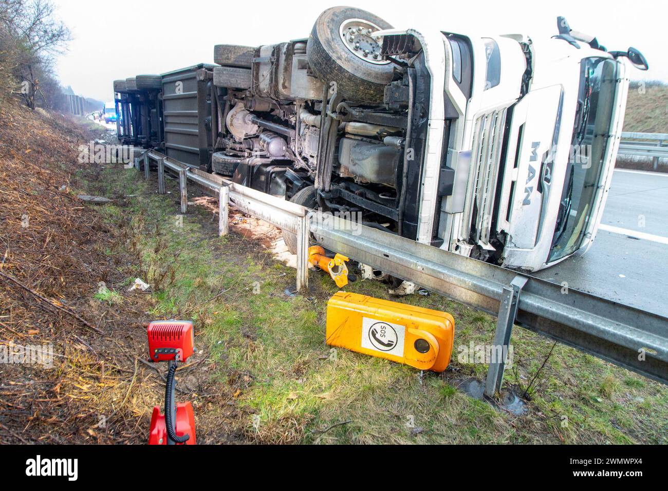 240228LKWUnfall News ID: EN 2024-02-28 LKW stürzt auf A72 um Fahrer bleibt unverletzt, Dieselkraftstoff ausgetreten A72 Höhe Leukersdorf. Auf der A72 in Richtung Hof Hat sich am Mittwochmorgen gegen 6 Uhr, zwischen den Anschlussstellen Chemnitz-Süd und Stollberg-Nord, ein LKW-Unfall ereignet. Der Fahrer des MAN War in Richtung Hof unterwegs, als er aus noch ungeklärter Ursache kurz nach dem Rastplatz Neukirchner Wald nach rechts von der Autobahn abkam, in einen Straßengraben fuhr und anschließend umkippte. Dabei wurde eine Leitplanke auf einer Länge von 50 Meter beschädigt. Auch eine Notrufsä Foto Stock