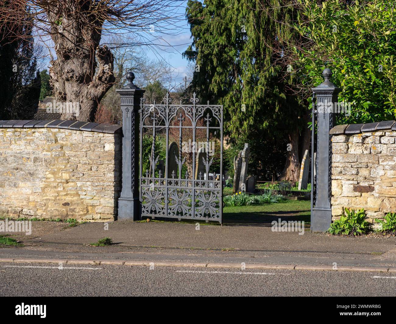 Cancelli in metallo ornato nero al cimitero del villaggio, Blisworth, Northamptonshire, Regno Unito Foto Stock