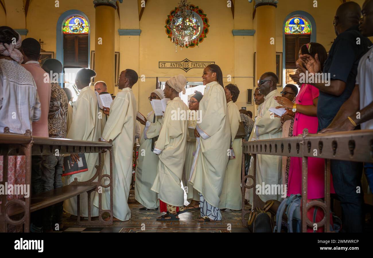 Il coro cattolico canta mentre cammina lungo la navata della Cattedrale di San Giuseppe all'inizio della messa domenicale a Stone Town, Zanzibar, Tanzania. Foto Stock