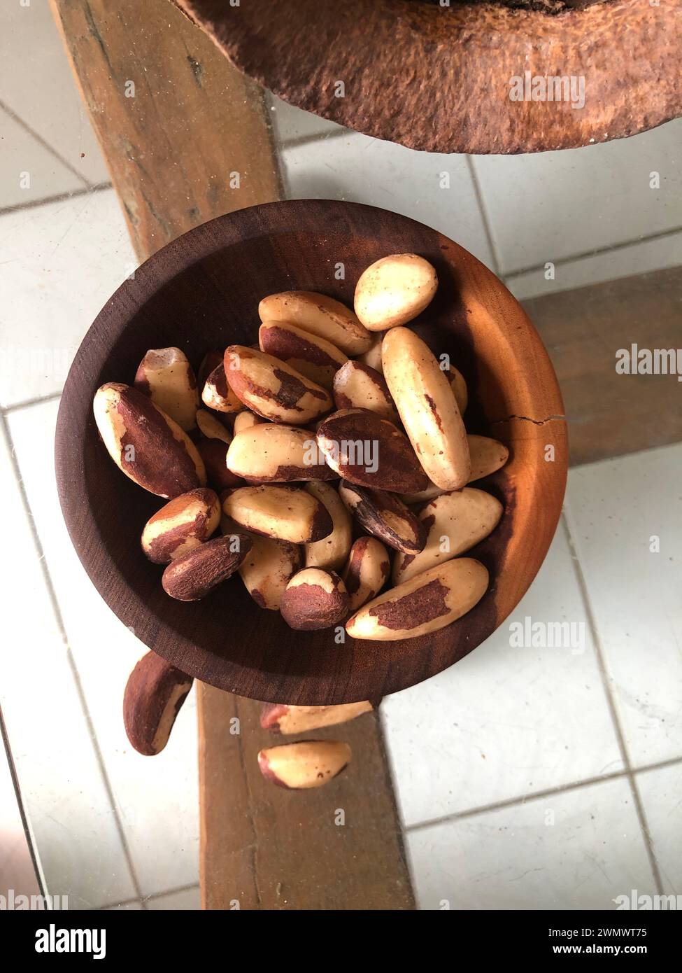 Noci brasiliane sul tavolo di vetro, noto come "Castanha do Pará". Ciotola di noci brasiliane sbucciate su sfondo grigio ardesia con spazio per copie Foto Stock