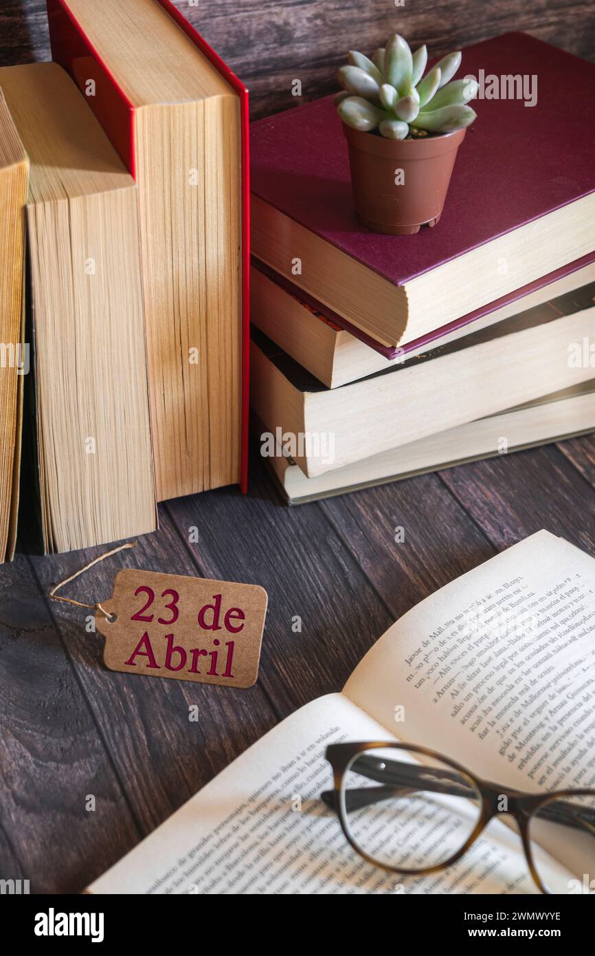 Libro aperto, occhiali in primo piano, un biglietto, pile di libri sullo sfondo. Giornata internazionale del libro, cultura, saggezza. Foto Stock
