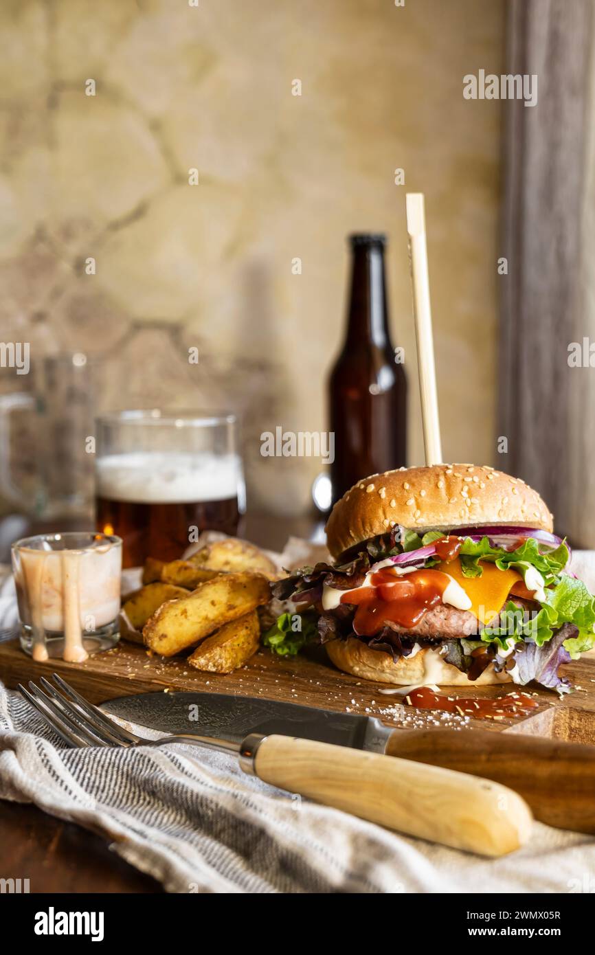 Appetitosi hamburger su un tavolo di legno, accompagnati da patatine fritte croccanti e birra rinfrescante, aspetto delizioso e allettante, shot verticale Foto Stock