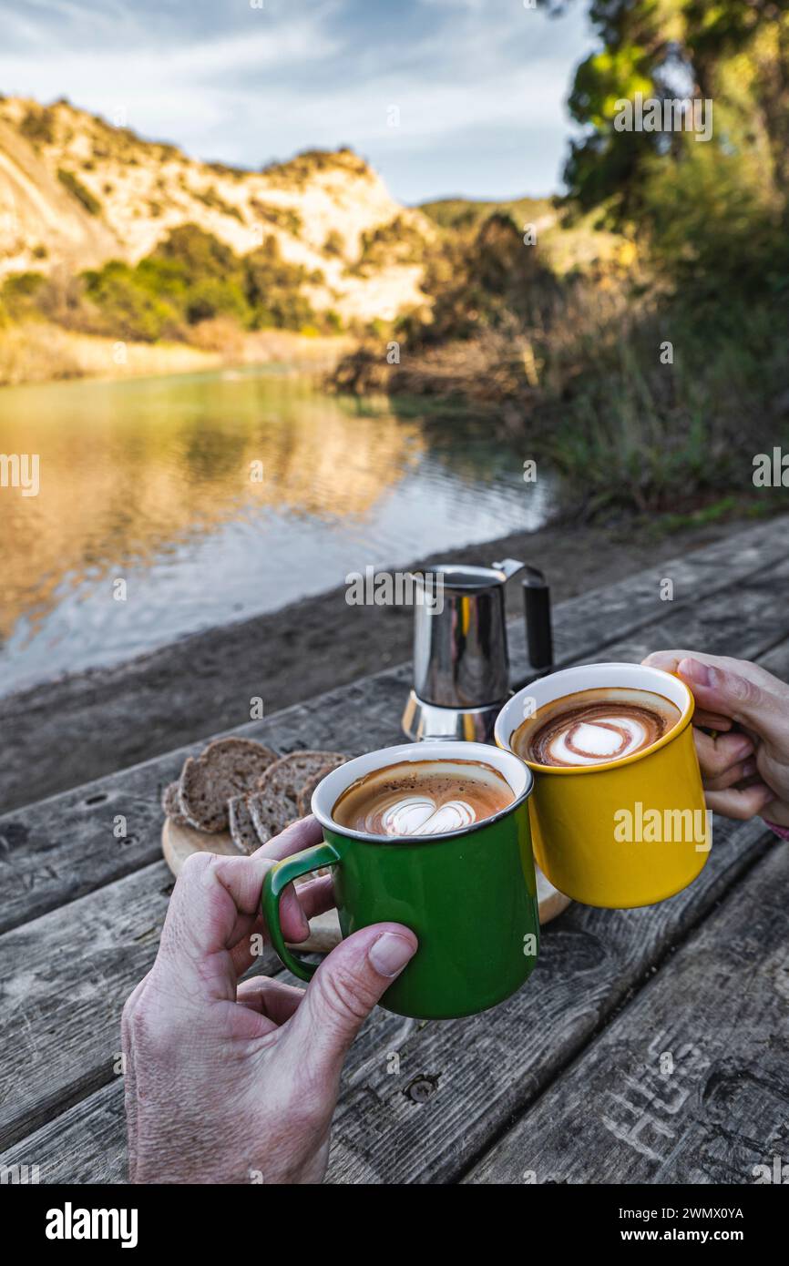 Colazione serena: Pane, caffè e toast sul fiume Tranquilo Foto Stock Colazione serena: Pane, caffè e toast sul fiume Tranquilo Foto Stock