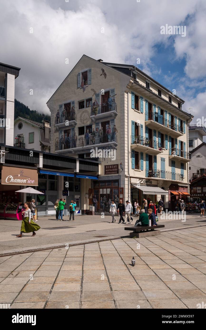 Rue du Dr Paccard con un palazzo decorato con un gigantesco murale raffigurante alcune delle più rinomate guide alpine della città alpina, Chamonix, Francia Foto Stock