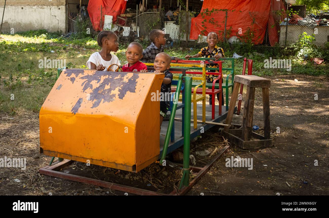 I bambini piccoli giocano su un'altalena a Stone Town, Zanzibar, Tanzania Foto Stock