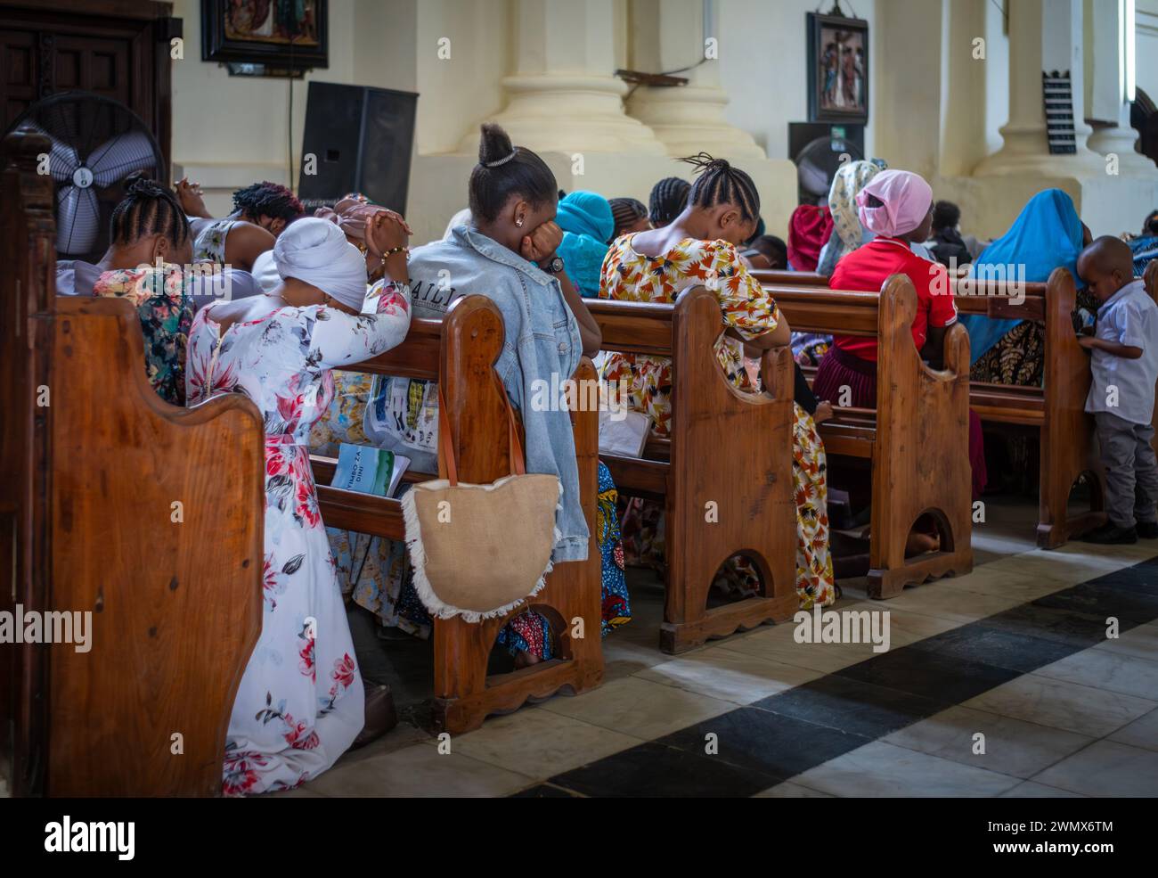 Le donne in abiti colorati pregano la domenica nella cattedrale anglicana Christ Church di Stone Town, Zanzibar, Tanzania. Foto Stock