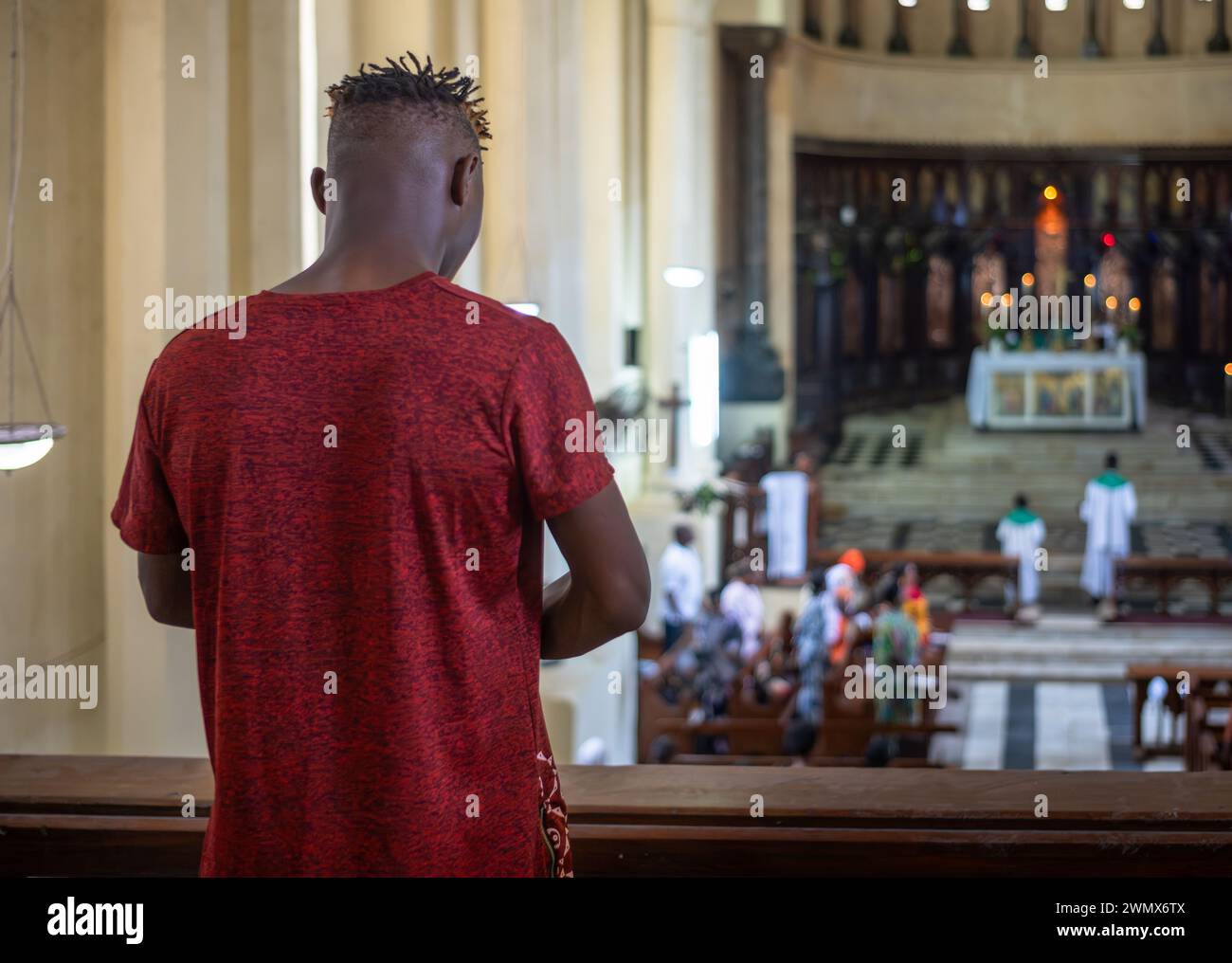 Un giovane con i piccoli timori e la testa rasata prega la domenica nella cattedrale anglicana di Christ Church a Stone Town, Zanzibar, Tanzania. Foto Stock