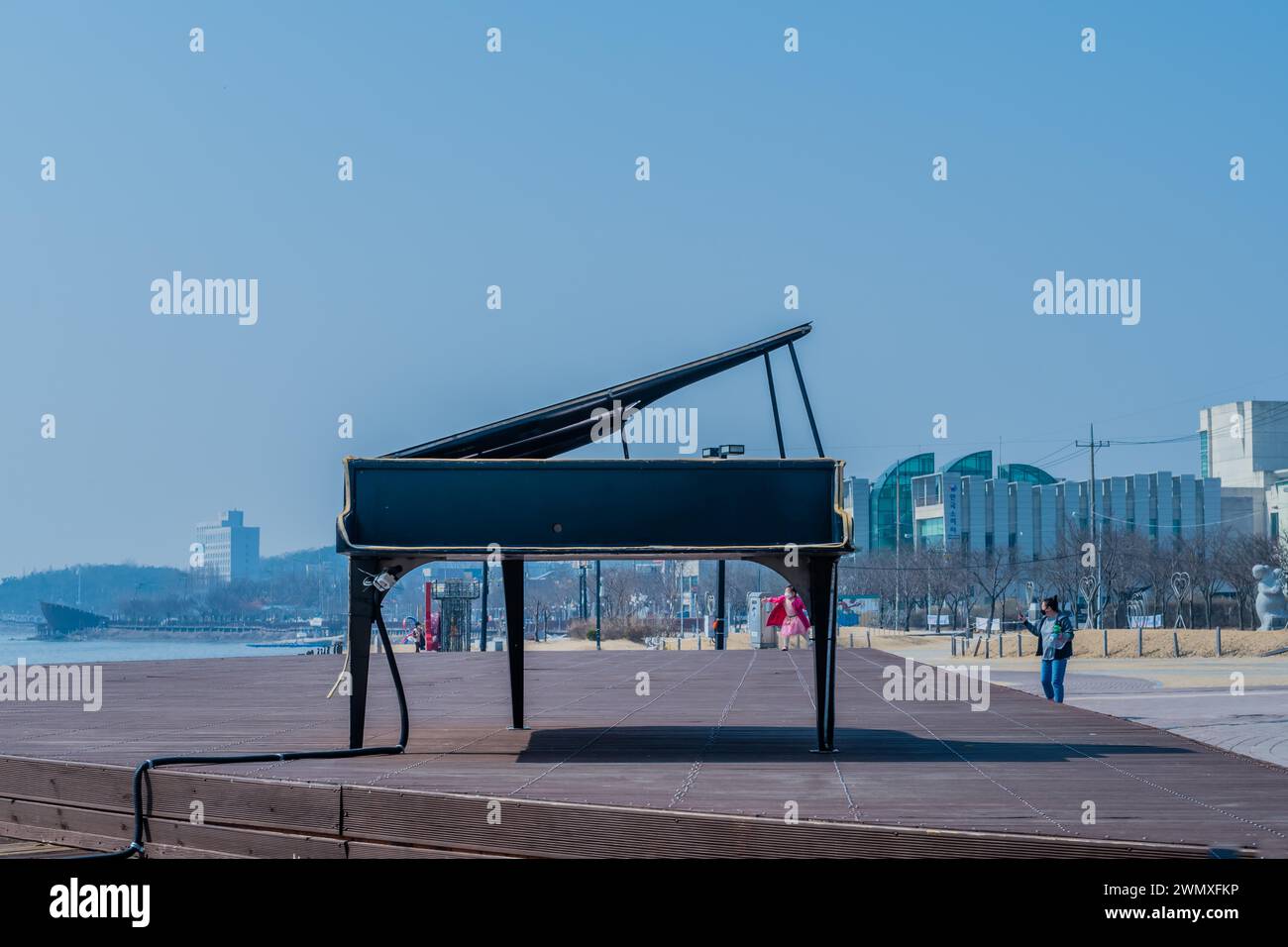 Un pianoforte a coda nero su una passerella sul lungofiume con coperchio aperto, in Corea del Sud Foto Stock