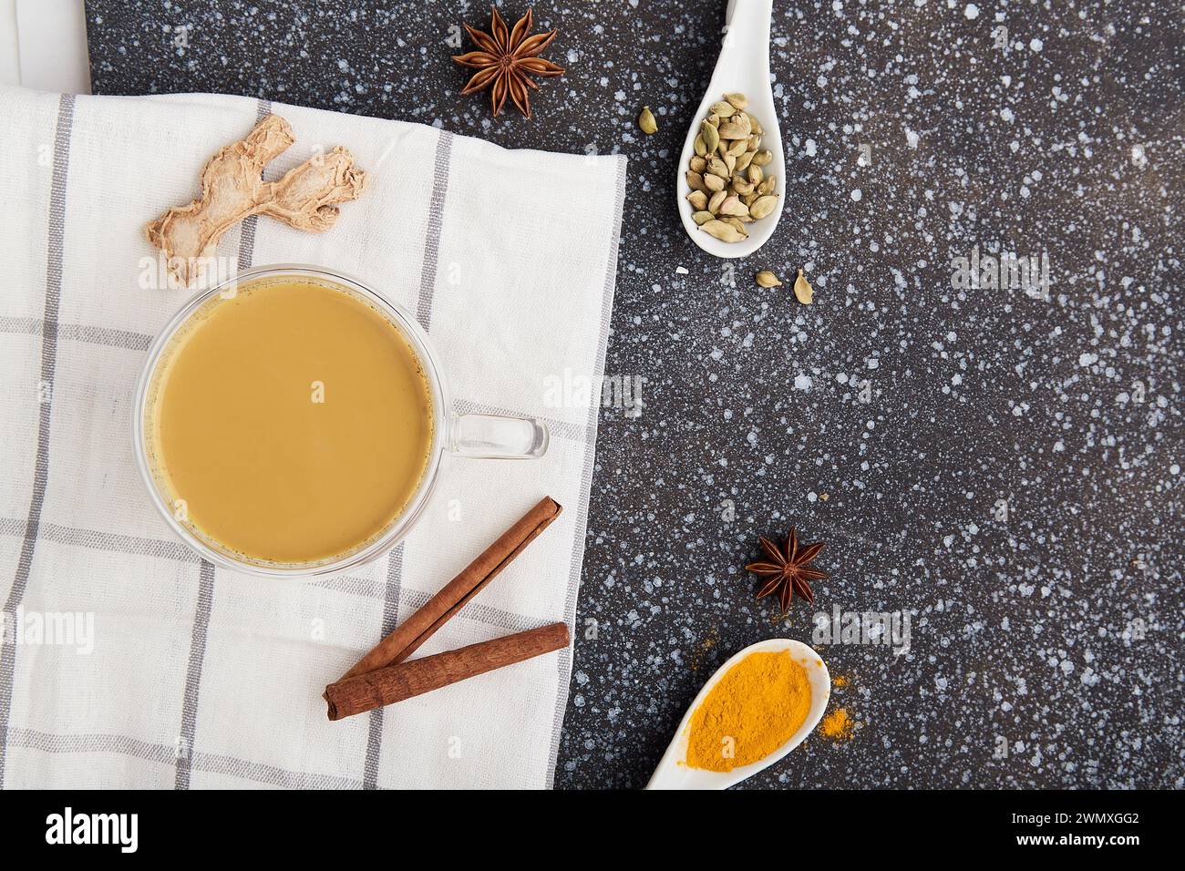 Tradizionale tè masala salutare - bevanda indiana con spezie curcuma, anice stellato, cardamomo nell'accogliente cucina con spazio copia. Foto Stock