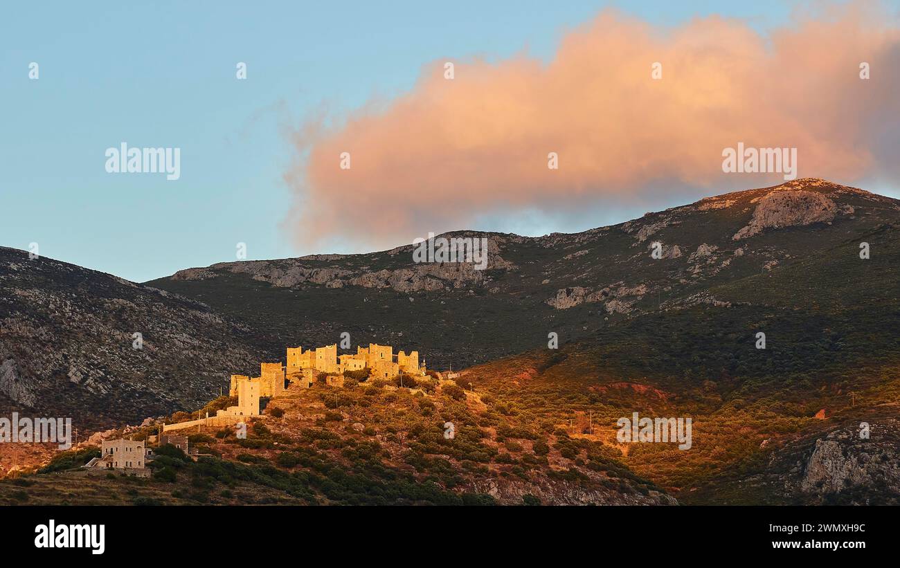 Maestosi edifici storici illuminati dal sole dell'ultima sera sulla cima di una collina, Vathia, villaggio residenziale di torri, penisola mani, Peloponneso, Grecia Foto Stock