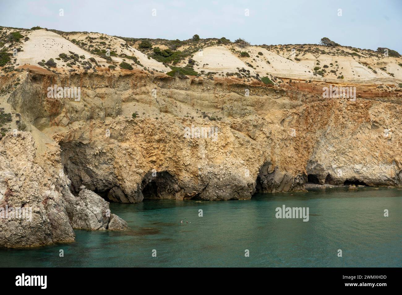 Grotte sulle scogliere vicino a Fylakopi, Milos, Cicladi, Grecia Foto Stock