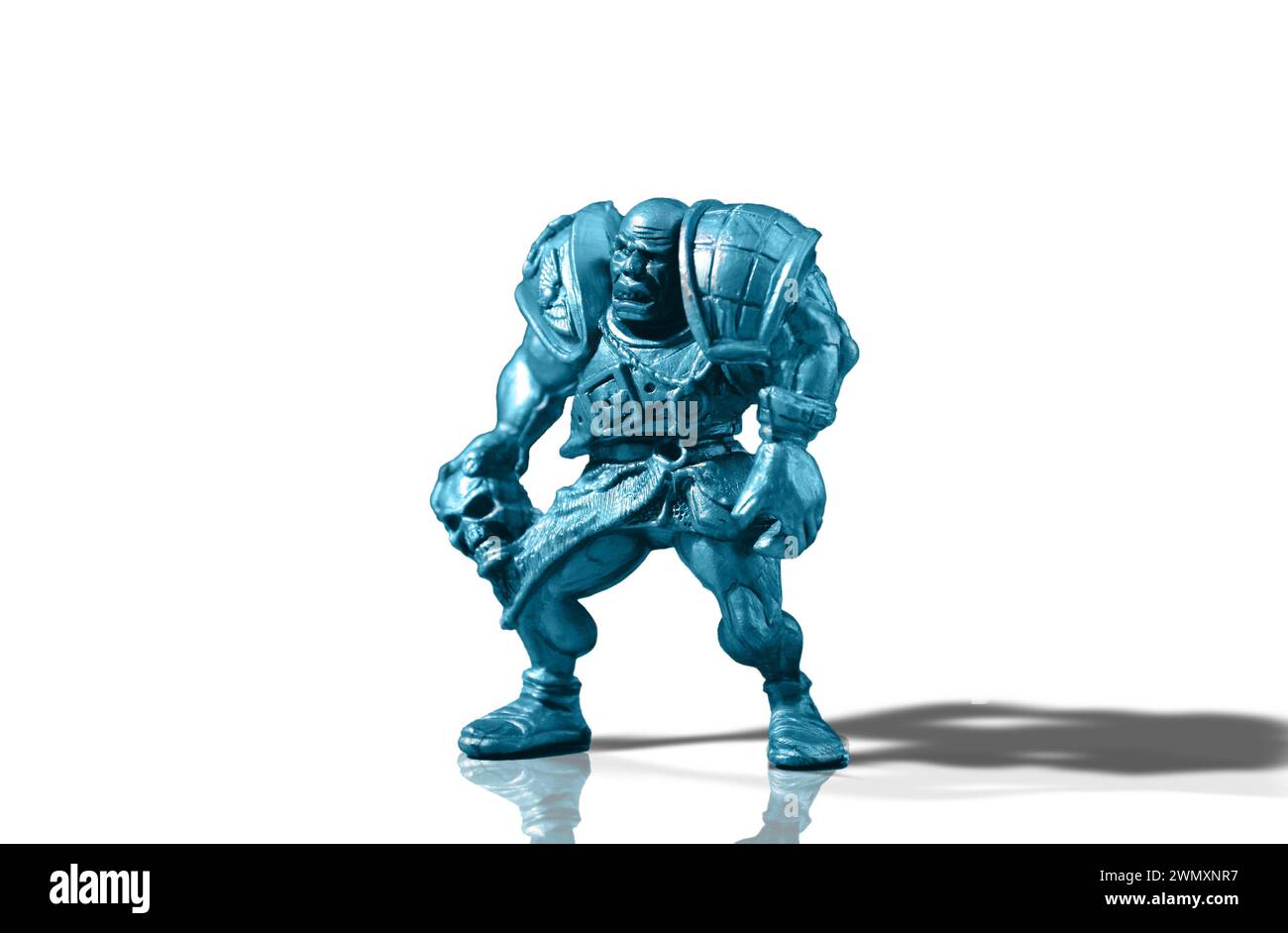 Figurina di un guerriero calvo aggressivo e vizioso in armatura con un cranio isolato su uno sfondo bianco con riflessi e ombre aggiunti Foto Stock